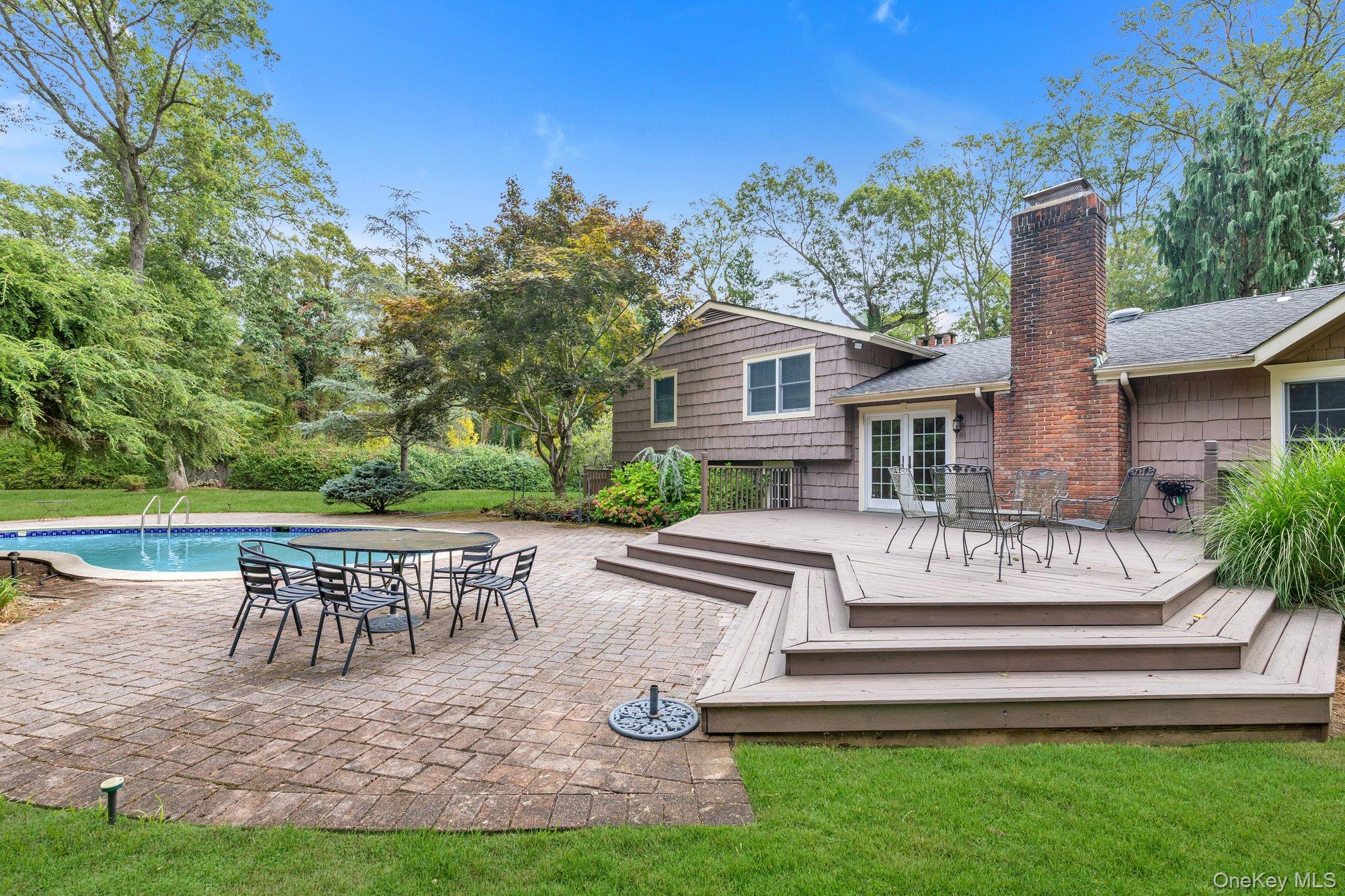 11 Quaker Ridge Road Glen Head, NY 11545 - Photo 5 of 32 Back of house to wood deck, brick patio and pool