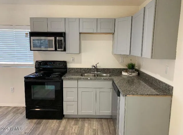 a kitchen with a sink stove and cabinets