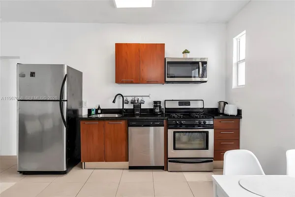a kitchen with stainless steel appliances granite countertop a stove a refrigerator and a sink