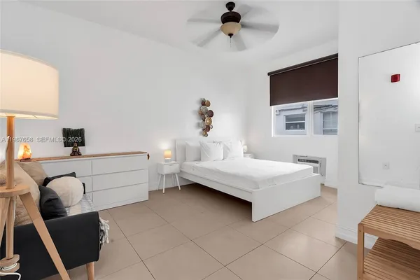 a bedroom with a bed and a flat tv screen on the dresser