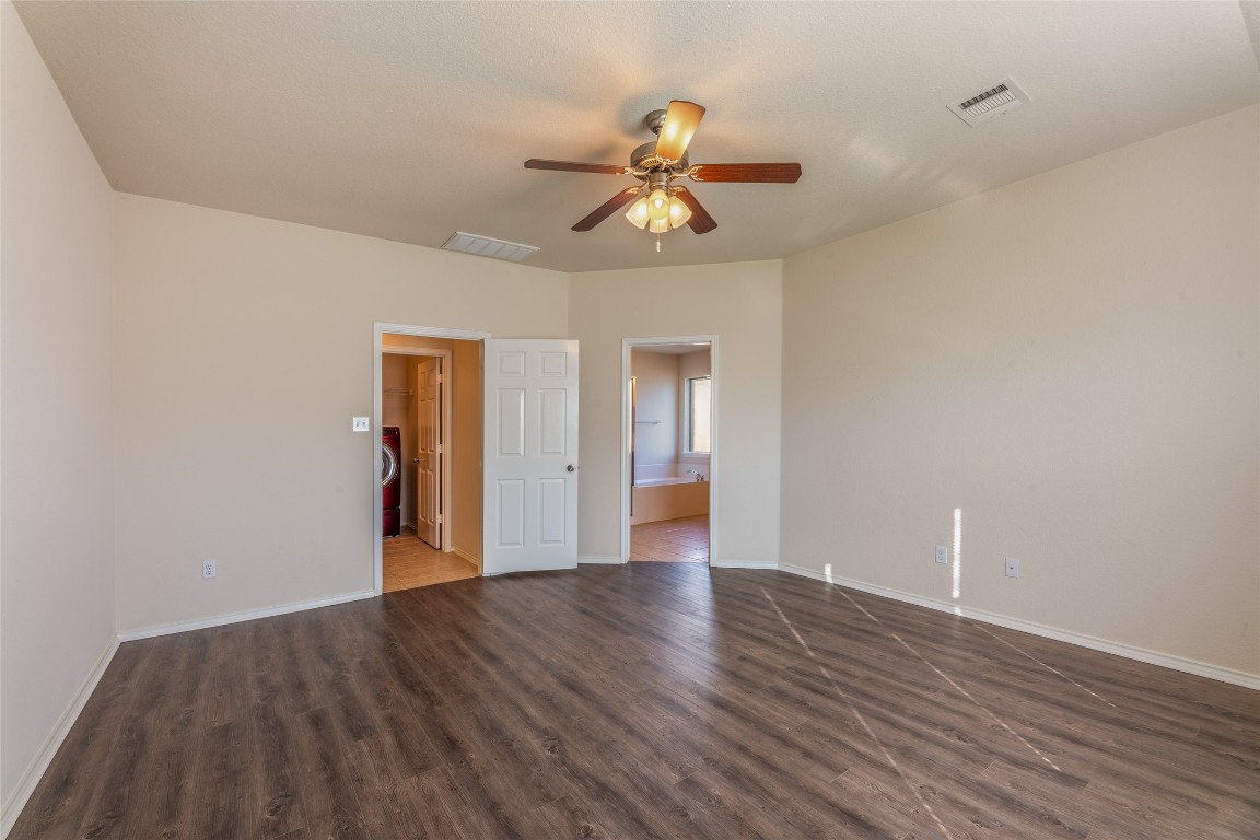 200 Falcon Lane Leander, TX 78641 - Photo 12 of 20 Unfurnished bedroom featuring ceiling fan, dark wood-style flooring, and ensuite bath