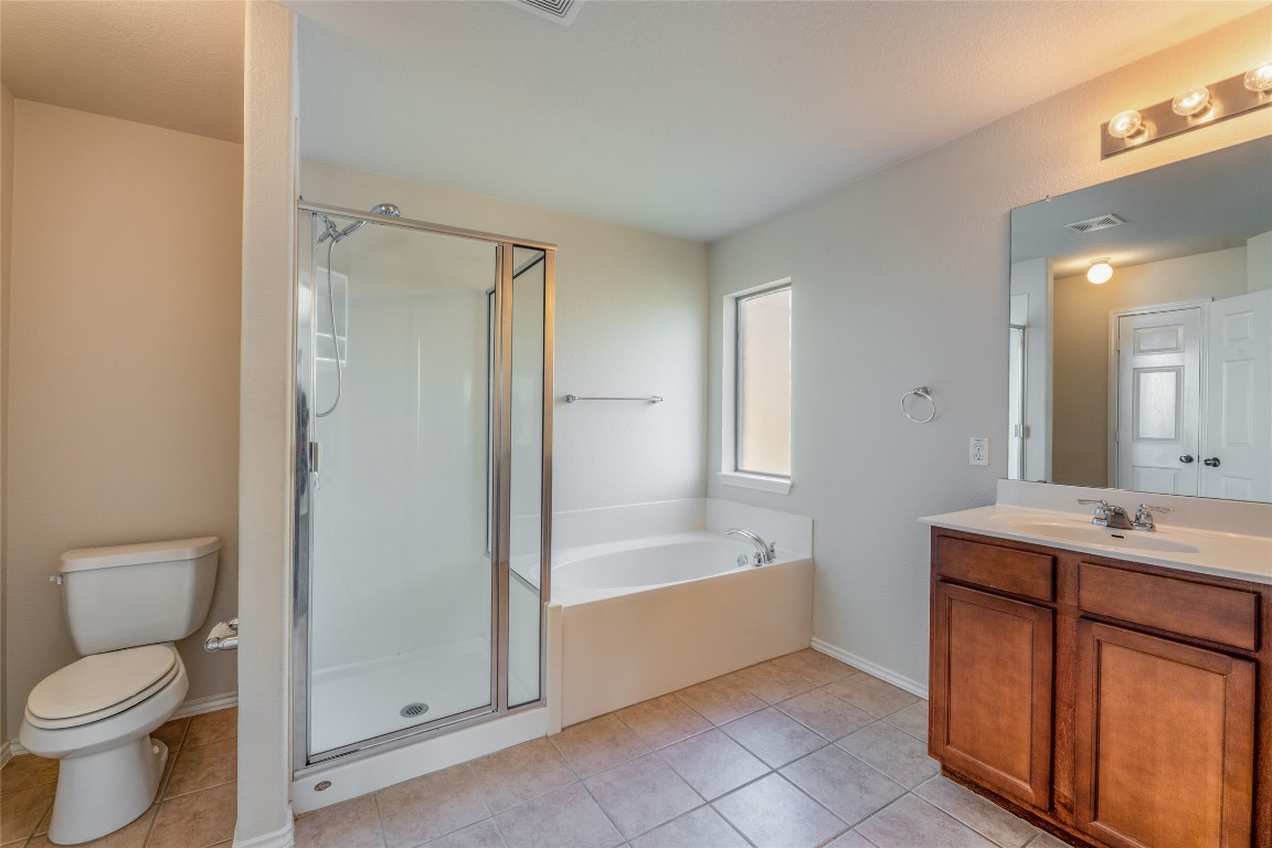 200 Falcon Lane Leander, TX 78641 - Photo 14 of 20 Bathroom featuring vanity, a stall shower, light tile patterned flooring, and a garden tub