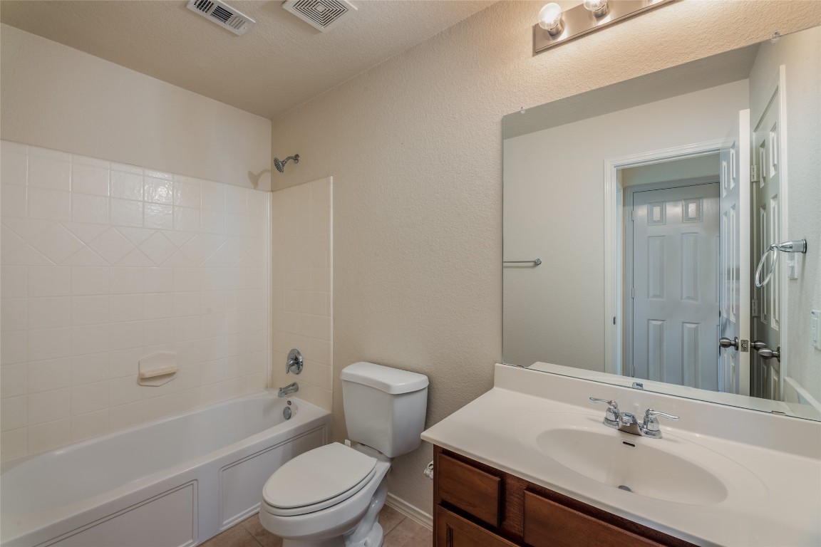 200 Falcon Lane Leander, TX 78641 - Photo 17 of 20 Full bathroom with shower / tub combination, vanity, light tile patterned floors, and a textured wall