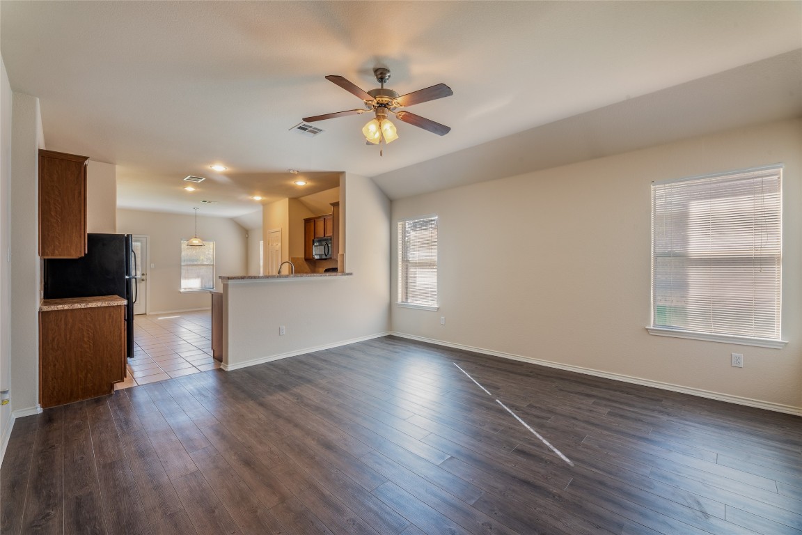 200 Falcon Lane Leander, TX 78641 - Photo 3 of 20 Unfurnished living room featuring ceiling fan, lofted ceiling, and dark wood-style floors