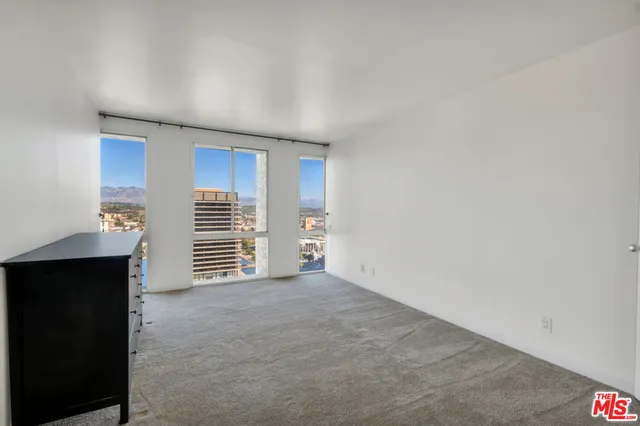 a view of empty room with fireplace and cabinet
