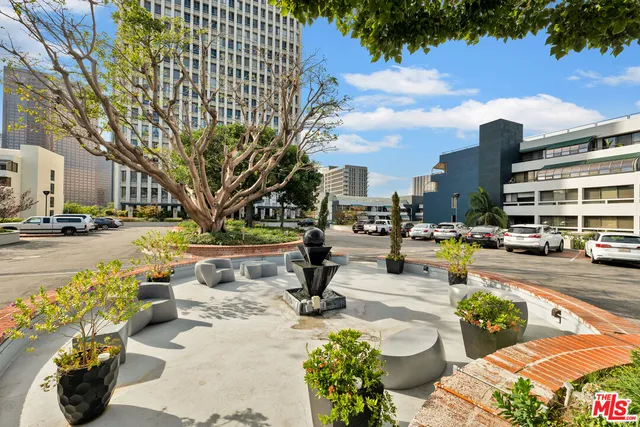 a roof deck with table and chairs and potted plants