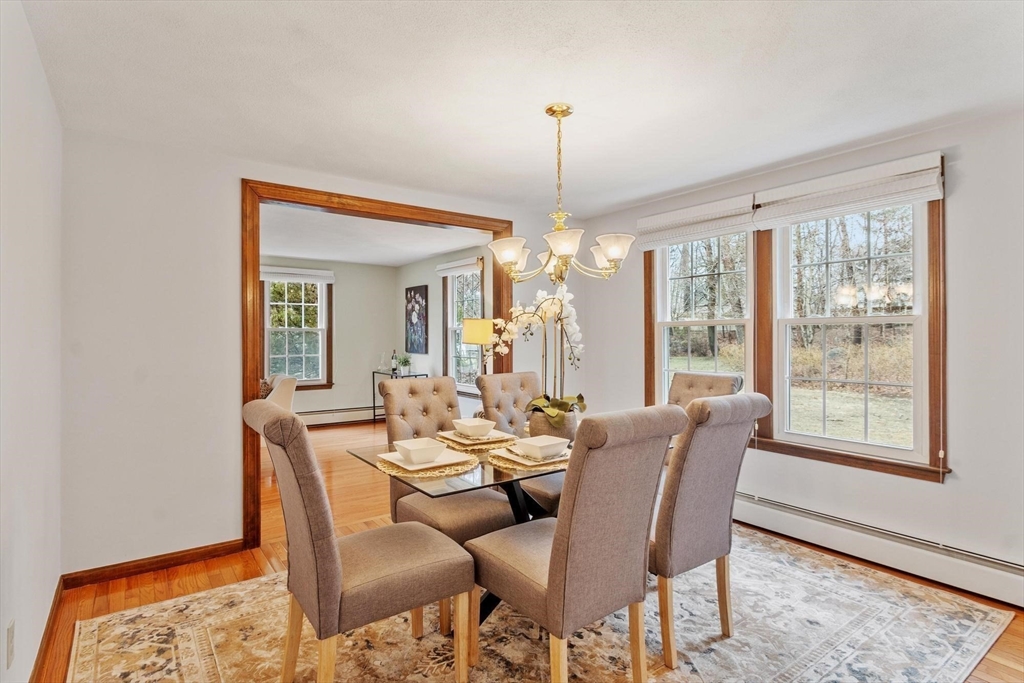 61 Beaver Road Reading, MA 01867 - Photo 16 of 39 a dining room with furniture a chandelier and wooden floor