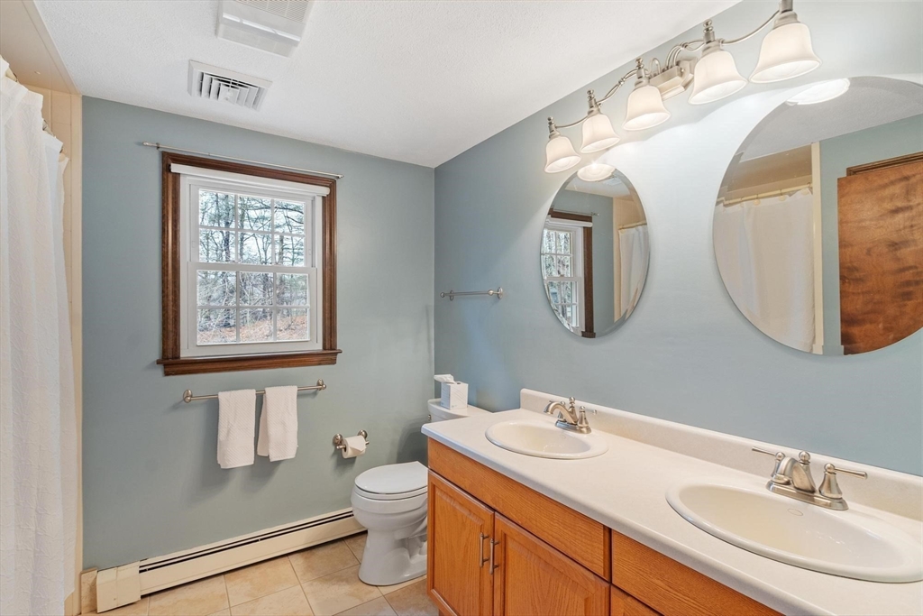 61 Beaver Road Reading, MA 01867 - Photo 26 of 39 a bathroom with a toilet a sink and mirror