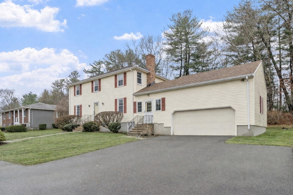 61 Beaver Road Reading, MA 01867 - Photo 3 of 39 a view of a white house with a yard and garage
