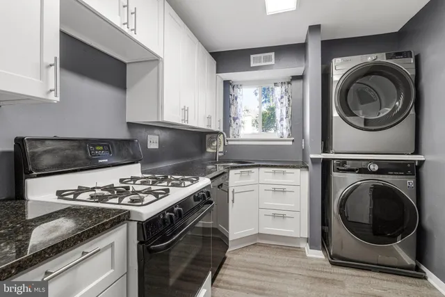 a kitchen with kitchen island a stove a sink and a microwave