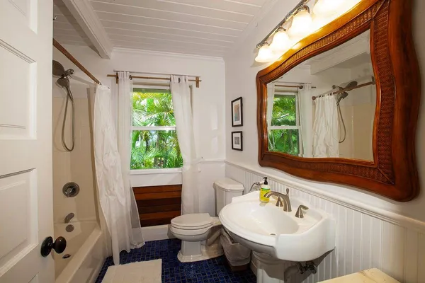 a bathroom with a sink a toilet and shower curtain