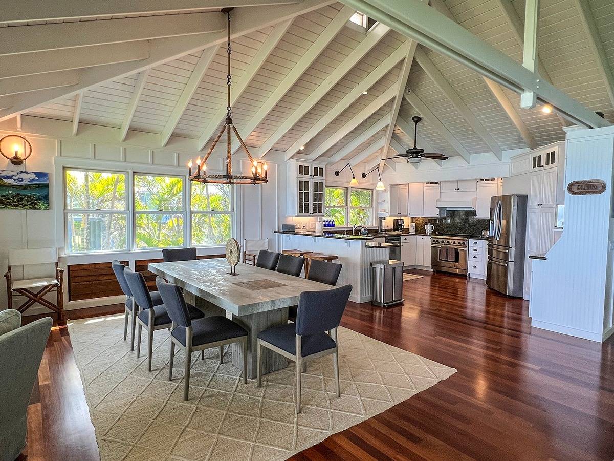 7324 Alealea Road Hanalei, HI 96714 - Photo 5 of 30 a dining room with wooden floor a chandelier a wooden table and chairs