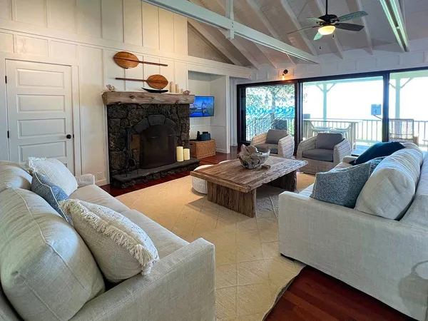 a living room with couches fireplace and a large window