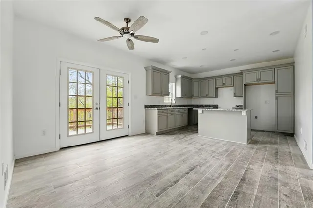 a view of an empty room with a window and kitchen