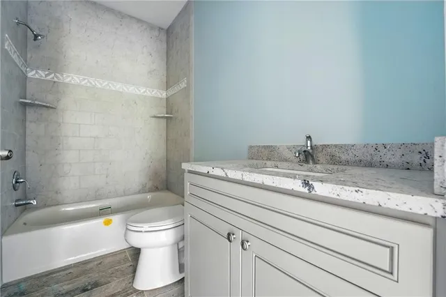 a bathroom with a granite countertop toilet a sink and bathtub