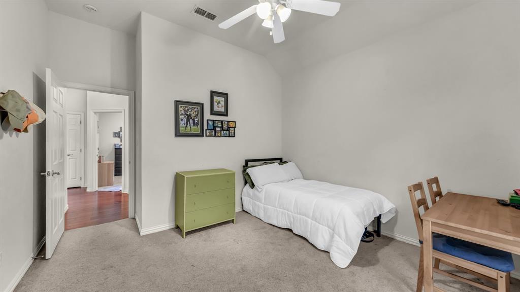 203 Mockingbird Lane Aledo, TX 76008 - Photo 33 of 37 Carpeted room featuring a ceiling fan, light gray wall paint, and a doorway opening to a hallway with wood-finish flooring