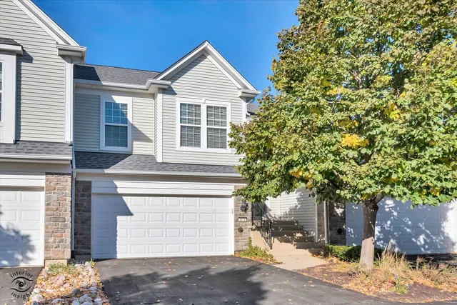 a front view of a house with a tree