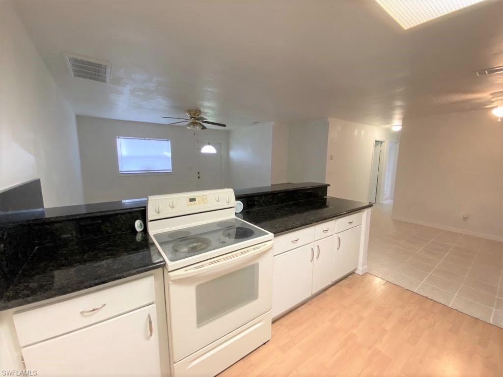 18457 Matanzas Road Fort Myers, FL 33967 - Photo 6 of 9 a kitchen with granite countertop white cabinets and white appliances