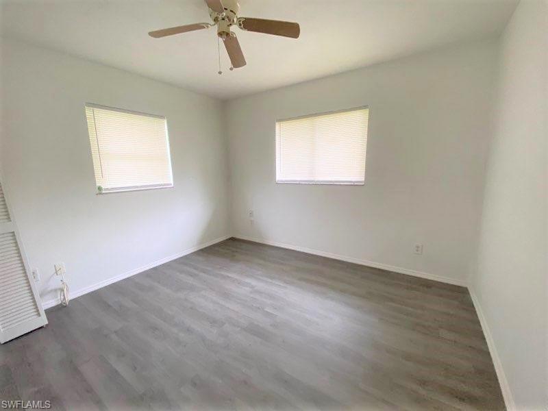 18457 Matanzas Road Fort Myers, FL 33967 - Photo 7 of 9 an empty room with wooden floor ceiling fan and windows