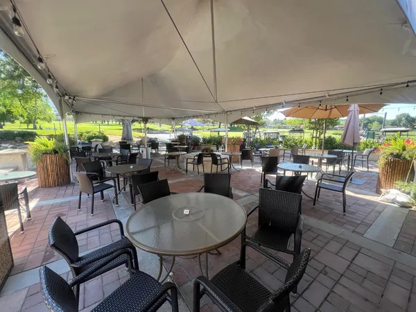 a outdoor space with lots of tables a large mirror and a sink