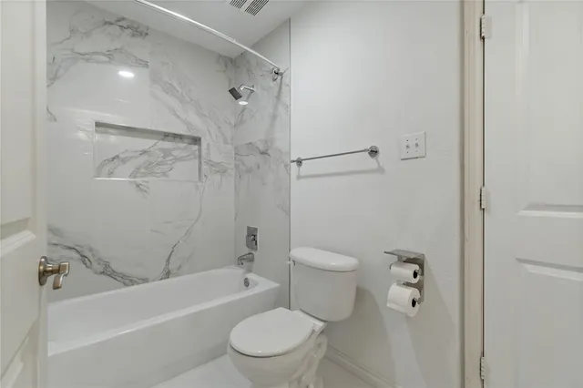a white toilet and tub sitting next to a bathroom sink