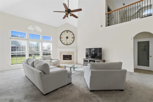 a living room with furniture a fireplace and a large window