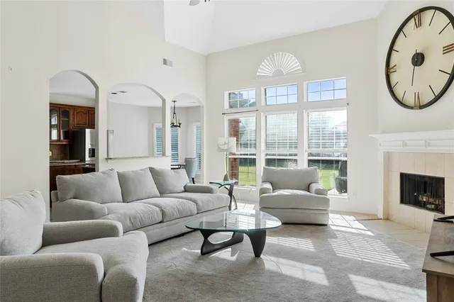 a living room with furniture a large window and a fireplace