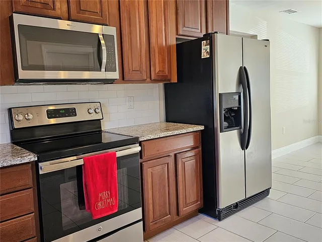 a kitchen with stainless steel appliances granite countertop a refrigerator stove and microwave