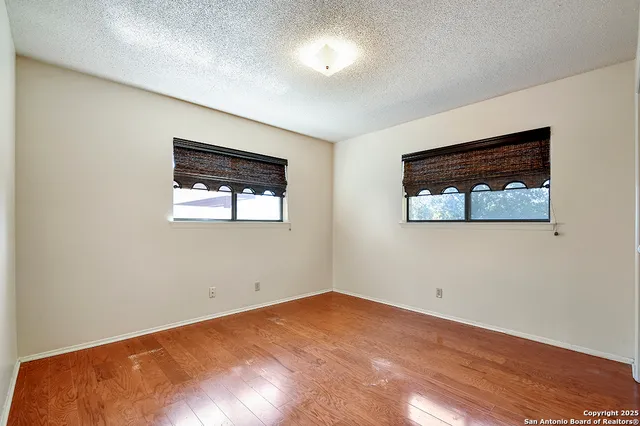 an empty room with wooden floor and window