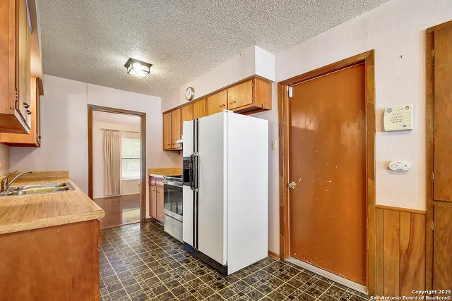 a kitchen with a refrigerator and a stove