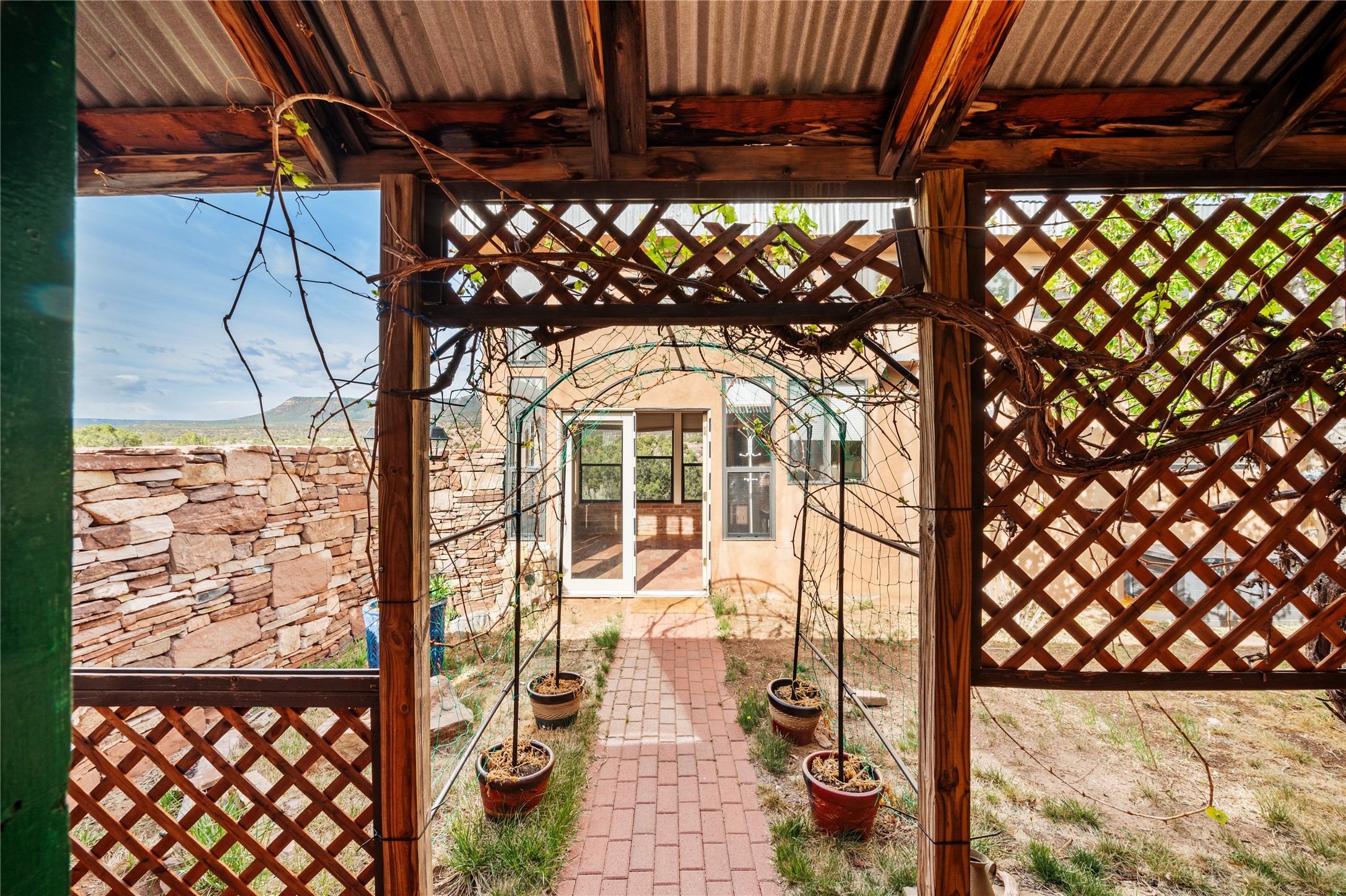 3-4 County Rd B41C San Jose, NM 87565 - Photo 17 of 41 Adobe home portal through courtyard towards studio.