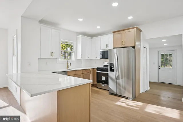 a kitchen with granite countertop a refrigerator and a sink