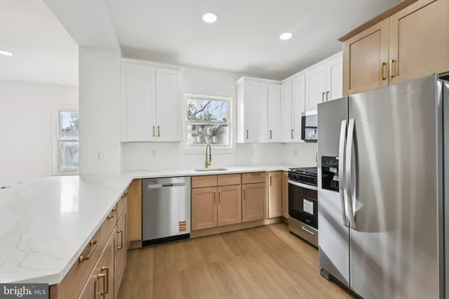 a kitchen with granite countertop a refrigerator stove and sink