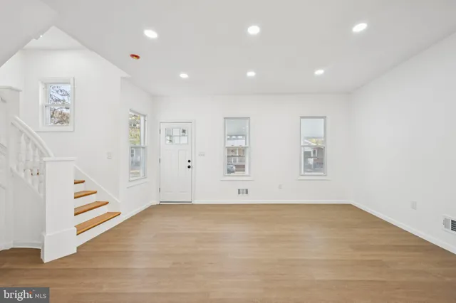 an empty room with staircase and white walls