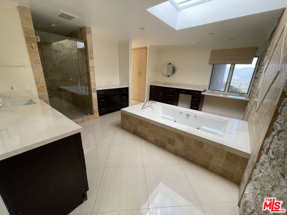 1743 Stone Canyon Road Los Angeles, CA 90077 - Photo 16 of 28 a living room with stainless steel appliances kitchen island granite countertop furniture and a fireplace