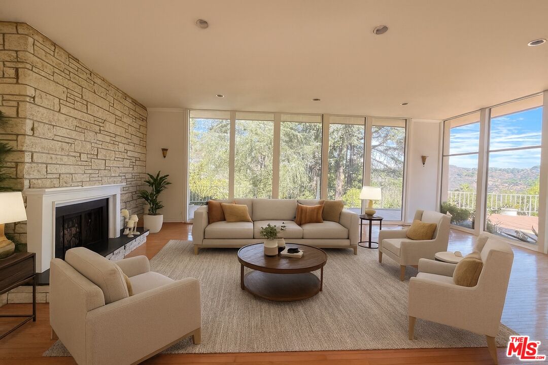 1743 Stone Canyon Road Los Angeles, CA 90077 - Photo 19 of 28 a living room with furniture and a fireplace