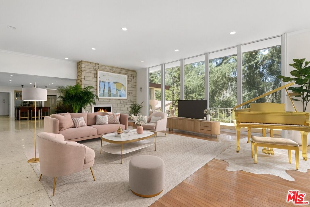 1743 Stone Canyon Road Los Angeles, CA 90077 - Photo 4 of 28 a living room with fireplace furniture and a large window