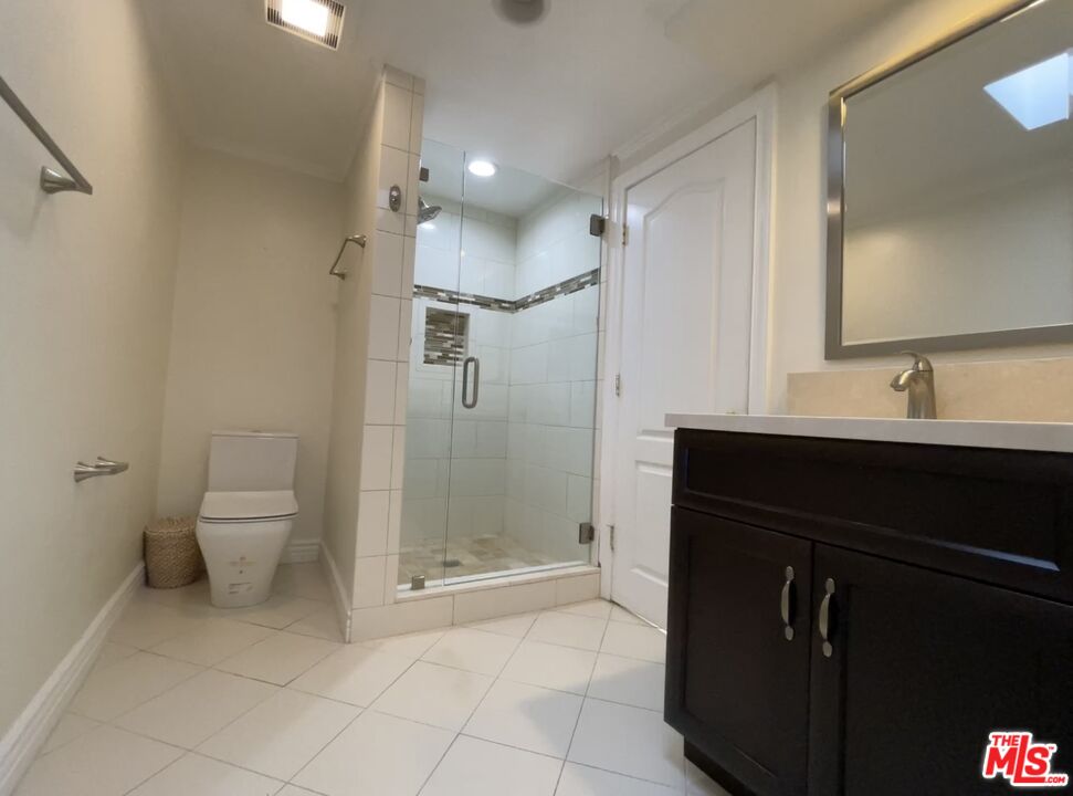 1743 Stone Canyon Road Los Angeles, CA 90077 - Photo 10 of 28 a bathroom with a double vanity sink toilet and shower