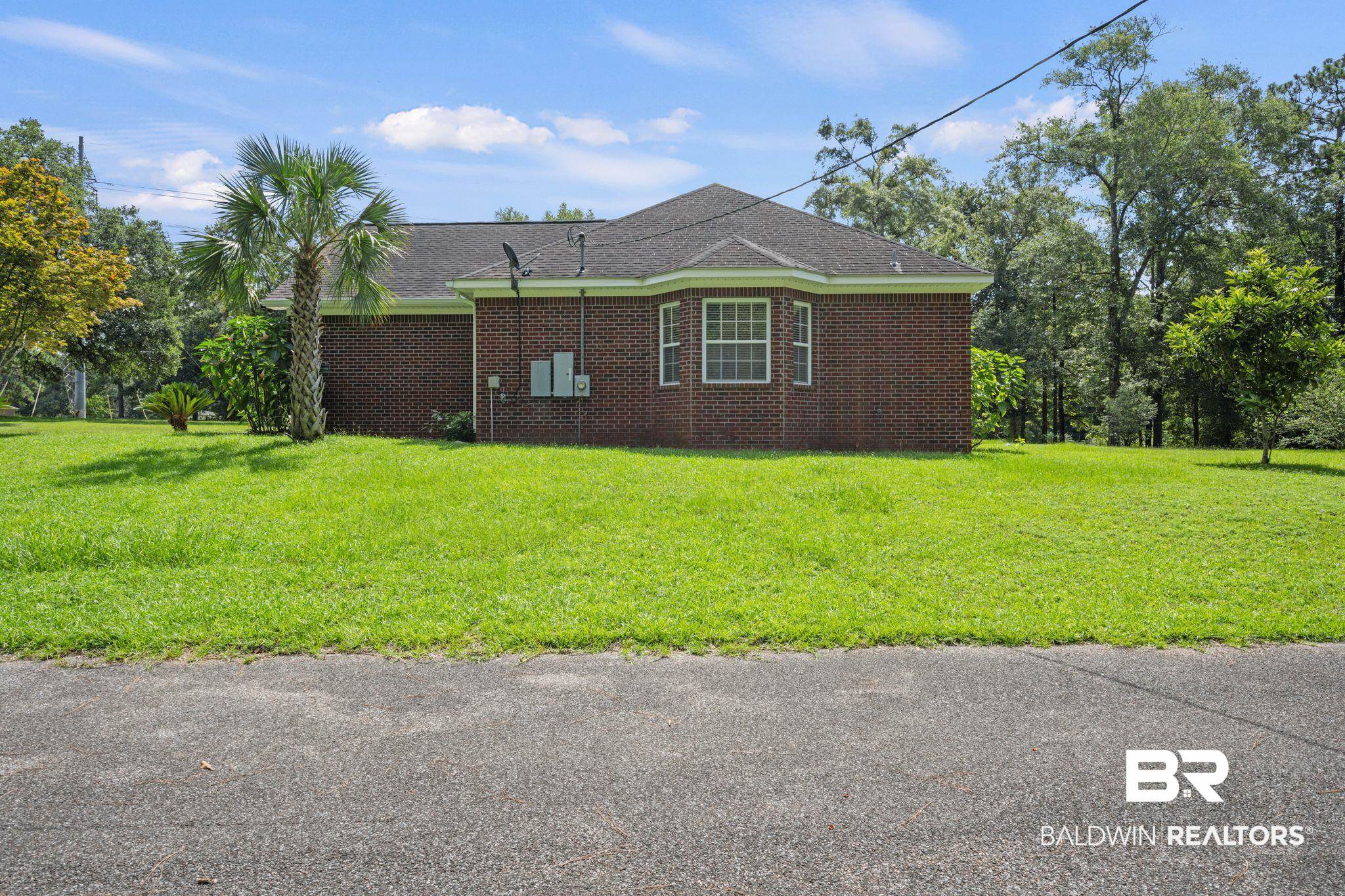 5618 Leytham Road Theodore, AL 36582 - Photo 42 of 60 View of property exterior with a lawn
