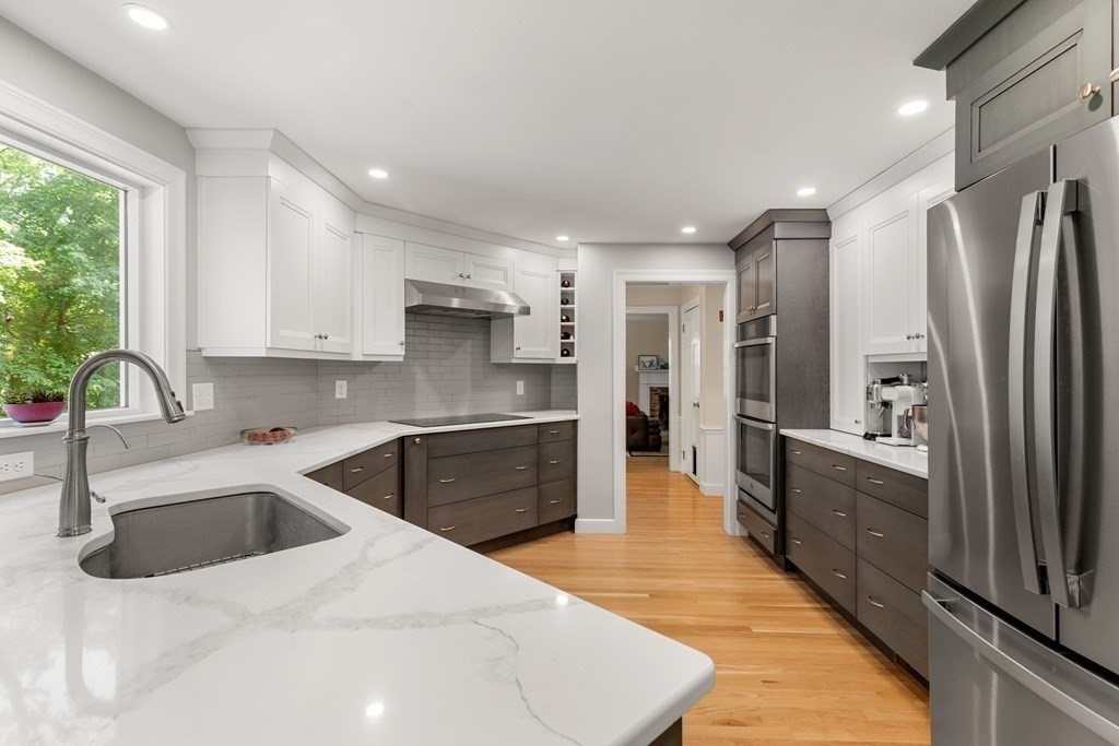 58 Old Coach Road Sudbury, MA 01776 - Photo 13 of 40 a kitchen with stainless steel appliances kitchen island granite countertop a refrigerator a sink a stove and oven with wooden floor