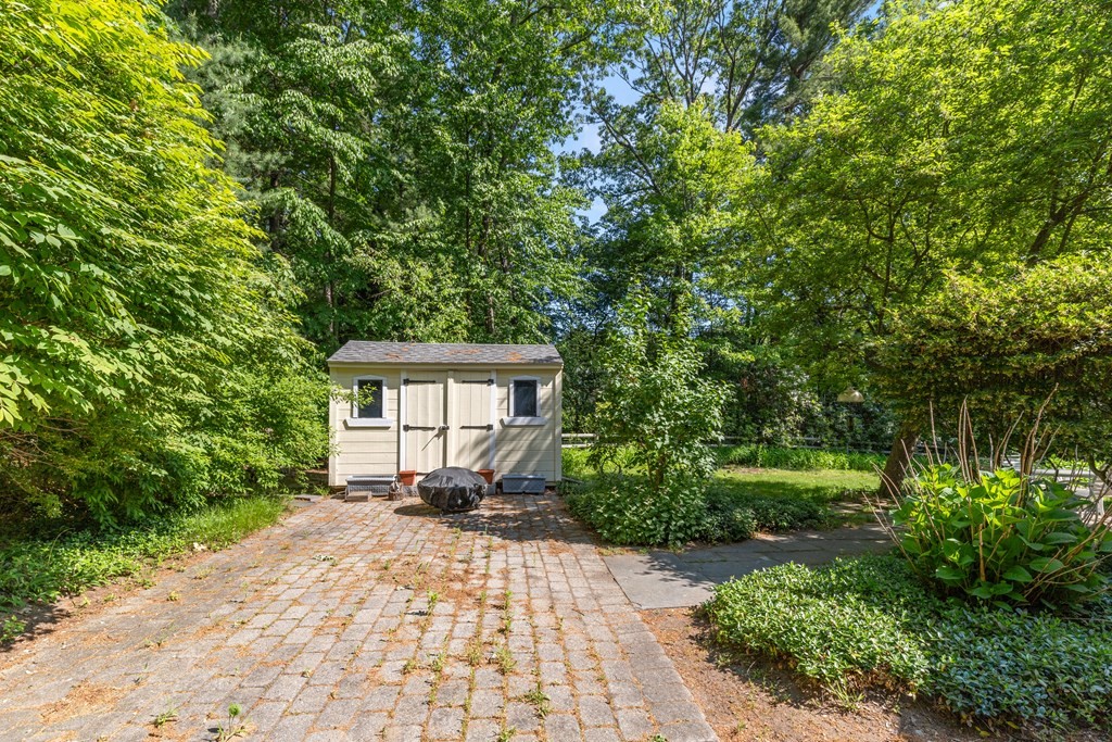 58 Old Coach Road Sudbury, MA 01776 - Photo 10 of 40 a front view of a house with a yard and a garage