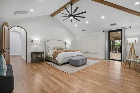 a bedroom with a large bed and a chandelier