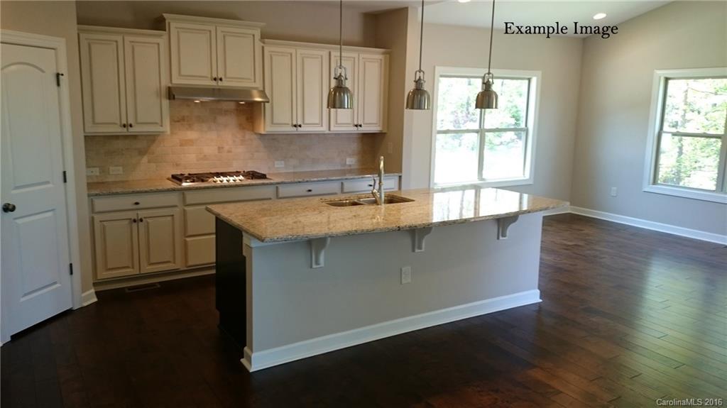 5271 Meadowcroft Way, Unit HAG0036 Fort Mill, SC 29708 - Photo 8 of 9 a kitchen with stainless steel appliances granite countertop a sink a stove a refrigerator cabinets and a wooden floor