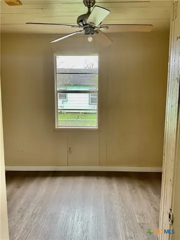 a view of a room with wooden floor and a window