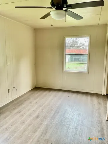 a view of a room with wooden floor and white wall
