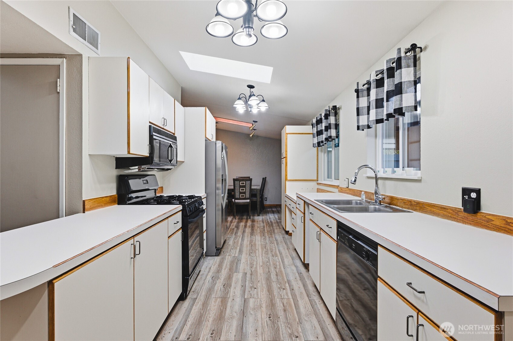 11090 25th Avenue Southwest Seattle, WA 98146 - Photo 9 of 38 a kitchen with a sink stove and cabinets