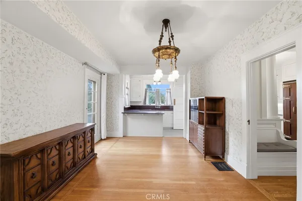 a view of empty room with wooden floor and window