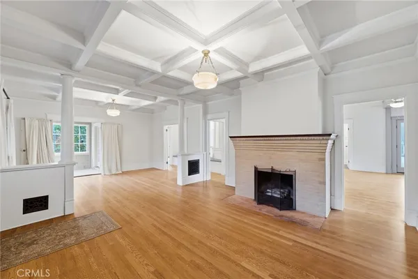 a view of empty room with wooden floor and fireplace