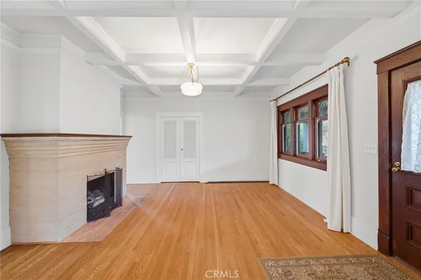a view of an empty room with window and wooden floor
