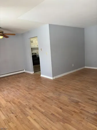 a view of an empty room with wooden floor